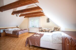 pokój z dwoma podwójnymi łóżkami i drewnianą podłogą